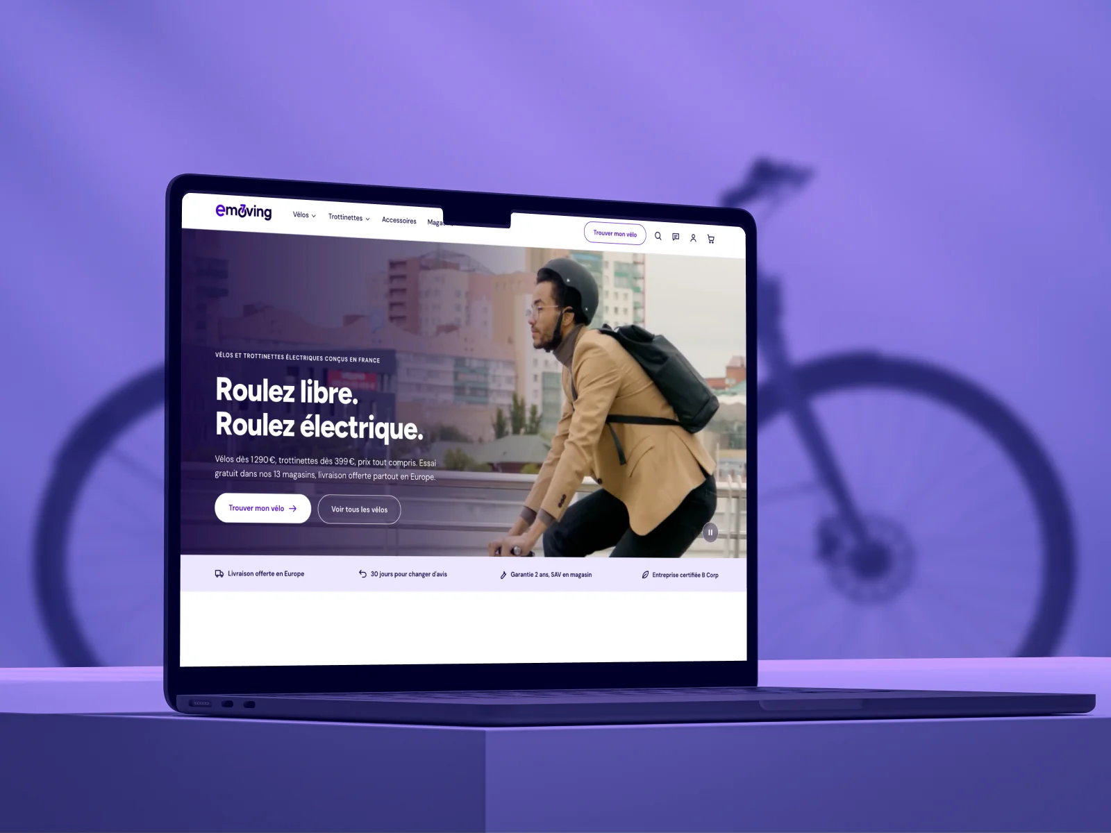 Le nouveau site Emoving sur un ordinateur portable, devant un vélo électrique sur fond violet